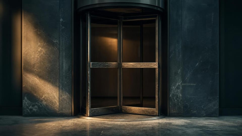 A revolving door with a visibly worn threshold from repeated use.