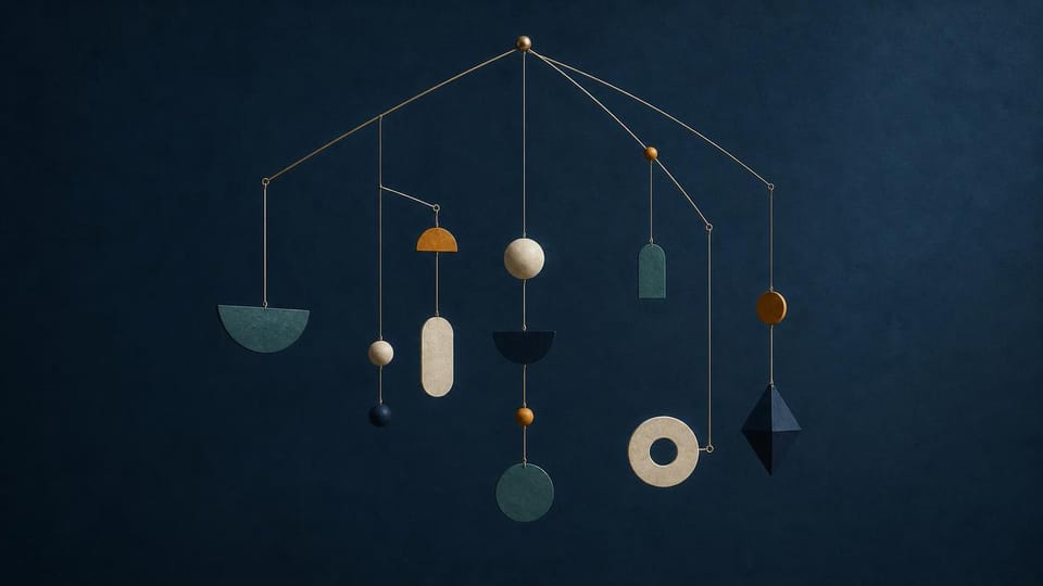 Balanced geometric mobile with varied shapes hanging at unequal intervals.