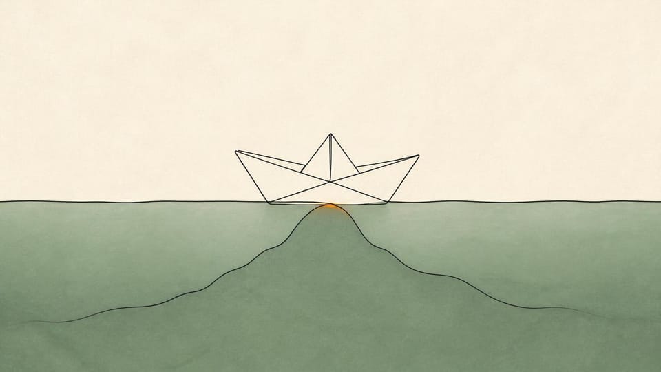 A paper boat snagged on a shallow ridge beneath calm water.